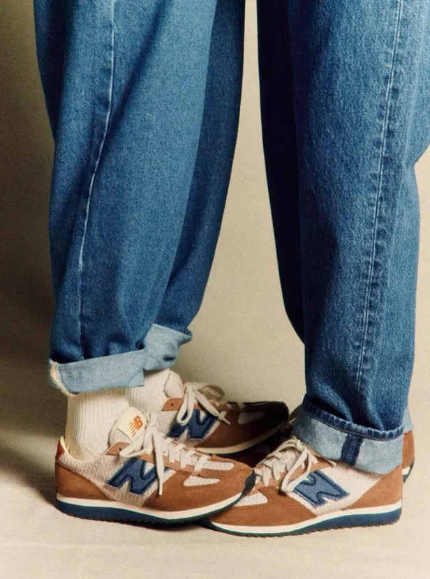 Two people wearing the New Balance Sézane 471 design sneakers. The photo shows only their legs. They're facing one another and the sneakers are touching at the toes